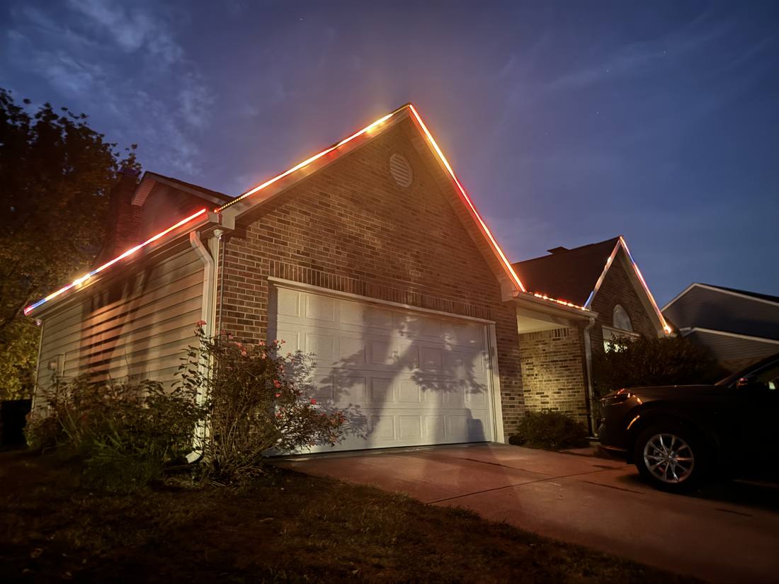 A Fishers home glowing warm at dusk with permanent House in Order roofline lighting